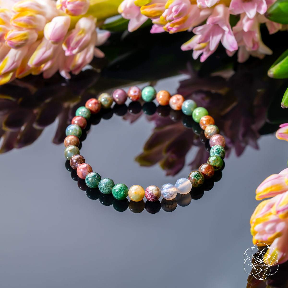 Energy Bracelet with polished round natural stone beads in varied green, rust, cream and pink mottled patterns, strung in a circle.