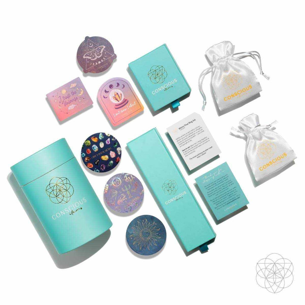 Energy Bracelet packaging set with turquoise Conscious boxes, colorful illustrated tins, printed cards, and white drawstring pouches.